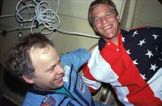 Mir-24 commander Anatoly Solovyev and STS-86 mission specialist Scott Parazynski exchange greetings.